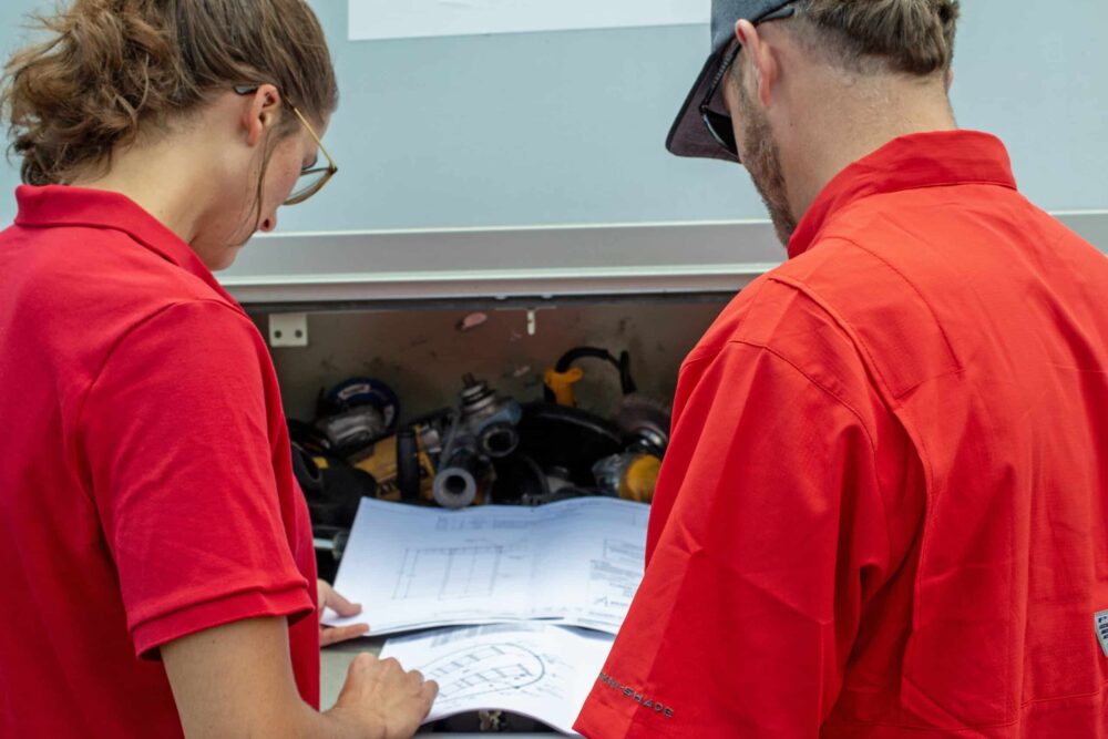 Field technicians inspecting tank drawings.